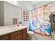 A primary bathroom featuring a colorful shower curtain, vanity, and towel rack at 271 Indian Wells Ave, Poinciana, FL 34759