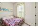 A view of the bedroom featuring a floral bed spread, a closet, and natural light at 271 Indian Wells Ave, Poinciana, FL 34759