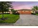 Charming single-story home featuring a paver driveway, lush landscaping, and a two-car garage at 271 Indian Wells Ave, Poinciana, FL 34759