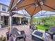 Beautiful backyard with covered patio, seating area, fire pit, and green space at 2939 Sera Bella Way, Kissimmee, FL 34744