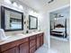 Bathroom boasting a double vanity, dark wood cabinets, granite counters, and an open view to the main bedroom at 2939 Sera Bella Way, Kissimmee, FL 34744