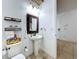 This well-lit bathroom features a pedestal sink and minimalist decor at 2939 Sera Bella Way, Kissimmee, FL 34744