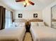 Comfortable bedroom with two full beds, ceiling fan, and natural light at 2939 Sera Bella Way, Kissimmee, FL 34744