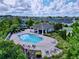 An aerial view of the community pool featuring a covered area, lounge chairs, and mature trees at 2939 Sera Bella Way, Kissimmee, FL 34744