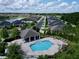 An aerial view of the community pool with a covered area, lounge chairs, and surrounding homes at 2939 Sera Bella Way, Kissimmee, FL 34744