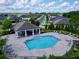 Aerial view of the community pool with a covered area, lounge chairs, and lush landscaping at 2939 Sera Bella Way, Kissimmee, FL 34744