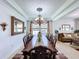 Open dining room leading to the living room, featuring a large table set and natural light at 2939 Sera Bella Way, Kissimmee, FL 34744