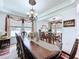 Formal dining room with a large wooden table, elegant chandelier, and views into the living room at 2939 Sera Bella Way, Kissimmee, FL 34744