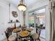 Elegant dining room with glass table set, chandelier, and sliding door to the patio at 2939 Sera Bella Way, Kissimmee, FL 34744