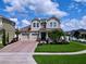 Charming two-story home with a well-manicured lawn, brick driveway, and a welcoming front porch at 2939 Sera Bella Way, Kissimmee, FL 34744