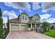 Charming two-story home with a well-manicured lawn, brick driveway, and a welcoming front porch at 2939 Sera Bella Way, Kissimmee, FL 34744