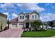 Charming two-story home with a well-manicured lawn, brick driveway, and a welcoming front porch at 2939 Sera Bella Way, Kissimmee, FL 34744