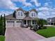 Charming two-story home with a well-manicured lawn, brick driveway, and a welcoming front porch at 2939 Sera Bella Way, Kissimmee, FL 34744