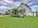 Beautifully landscaped front yard featuring a lush green lawn and decorative planting beds with a manicured palm tree at 2939 Sera Bella Way, Kissimmee, FL 34744