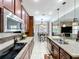 Open kitchen with stainless steel appliances, granite counters, central island and tile flooring at 2939 Sera Bella Way, Kissimmee, FL 34744
