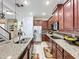 Open kitchen with stainless steel appliances, granite counters, central island and tile flooring at 2939 Sera Bella Way, Kissimmee, FL 34744