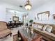 Elegant living room and dining area featuring a decorative mirror, chandelier lighting, and a large sofa at 2939 Sera Bella Way, Kissimmee, FL 34744