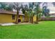Backyard view of house featuring a lawn, palm trees, and fence at 3 Rosewood Dr, Davenport, FL 33837