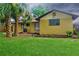 Backyard view of house featuring a lawn, palm trees, and AC unit at 3 Rosewood Dr, Davenport, FL 33837