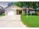 Charming single-story home with a brick facade, attached garage, and a well-maintained lawn at 3 Rosewood Dr, Davenport, FL 33837