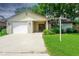 Charming single-story home with a brick facade, attached garage, and a well-maintained lawn at 3 Rosewood Dr, Davenport, FL 33837