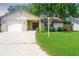 Exterior view of home featuring a lawn, garage, and driveway at 3 Rosewood Dr, Davenport, FL 33837