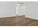 Bright living room featuring new wood floors, white walls, ceiling fan, and access to hallway and rooms at 3 Rosewood Dr, Davenport, FL 33837