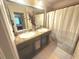 Bathroom with double sink vanity, shower with curtain, and decorative vase at 3162 Rodrick Cir, Orlando, FL 32824