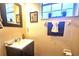 Bright bathroom with a single sink vanity, artwork, and a window providing natural light at 3162 Rodrick Cir, Orlando, FL 32824