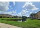 Scenic view of community pond reflecting townhouses against a blue sky with puffy clouds at 3162 Rodrick Cir, Orlando, FL 32824