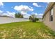 Expansive backyard featuring a well-maintained lawn, a white fence, and ample space for outdoor activities at 326 Highland Meadows Ave, Davenport, FL 33837