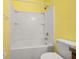 Bathroom with a tub, toilet, and shower under yellow walls at 326 Highland Meadows Ave, Davenport, FL 33837