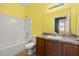 Bathroom with a tub, mirror, and toilet under yellow walls at 326 Highland Meadows Ave, Davenport, FL 33837