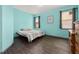 Bedroom with two windows, dark hardwood floors, and calming aqua walls at 326 Highland Meadows Ave, Davenport, FL 33837