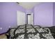 Bedroom featuring lavender walls, a window, closet doors, and a black patterned bedspread at 326 Highland Meadows Ave, Davenport, FL 33837