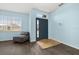 Bright entryway featuring modern wood-look floors, a large window, and a comfortable lounge chair at 326 Highland Meadows Ave, Davenport, FL 33837