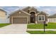 Charming single-Gathering home featuring a two-car garage, well-maintained lawn, and inviting front entrance at 326 Highland Meadows Ave, Davenport, FL 33837