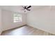 Bright, updated bedroom with light wood floors, white walls, a ceiling fan, and large window at 3621 Devonswood Dr, Orlando, FL 32806