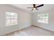 Bright bedroom with light wood floors, white walls, ceiling fan, and two windows providing natural light at 3621 Devonswood Dr, Orlando, FL 32806