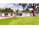Charming single-story home with a red door and a well-manicured lawn under a blue sky at 3621 Devonswood Dr, Orlando, FL 32806