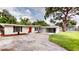 Ranch style home with a red front door and a covered carport at 3621 Devonswood Dr, Orlando, FL 32806