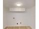 Bright laundry room with shiplap walls, overhead cabinets, and wood-look floors at 3621 Devonswood Dr, Orlando, FL 32806