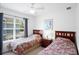 Bedroom features standard windows, ceiling fan, and twin beds with a red and green patterned bedspread at 4014 Santa Maria Dr # 101, Kissimmee, FL 34741
