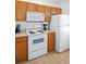 Efficient kitchen featuring white appliances and wood cabinets, ideal for cooking and storage at 4014 Santa Maria Dr # 101, Kissimmee, FL 34741