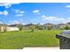 Open backyard area with a vibrant green lawn, perfect for enjoying the outdoors, includes gas grill at 4492 Bluff Oak Loop, Kissimmee, FL 34746