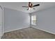 The carpeted bedroom is complete with a ceiling fan and ample natural light from the window at 4492 Bluff Oak Loop, Kissimmee, FL 34746