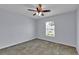 This carpeted bedroom features a ceiling fan and a window for natural light at 4492 Bluff Oak Loop, Kissimmee, FL 34746