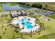 An aerial view showcasing the community pool, clubhouse, and playground amidst lush landscaping and parking at 4492 Bluff Oak Loop, Kissimmee, FL 34746