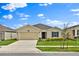 Inviting single-story home showcases a well-maintained lawn and a convenient two-car garage under a blue sky at 4492 Bluff Oak Loop, Kissimmee, FL 34746