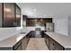 Contemporary kitchen with dark wood cabinetry, stainless steel appliances, and a large center island at 4492 Bluff Oak Loop, Kissimmee, FL 34746
